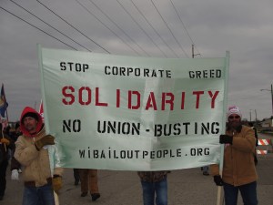 Machinists Local 516 members carrying WI Bail Out The People Movement banner in Manitowoc solidarity march Dec. 10.